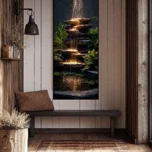 Puede incluir: Una impresión artística vertical de una cascada escalonada con luces brillantes, rodeada de exuberantes plantas verdes. La obra de arte se exhibe en un interior rústico con paredes de madera, un banco y una alfombra.