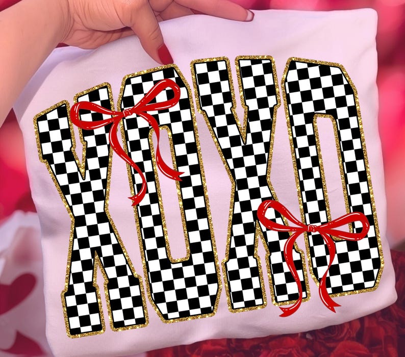 Puede incluir: Camiseta blanca con las letras XOXO en un patr&oacute;n de cuadros blanco y negro, contorneadas con purpurina dorada. Lazos rojos adornan las letras. La camiseta est&aacute; sujeta por una persona.