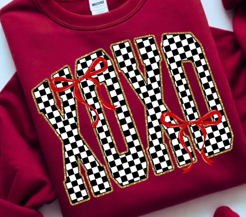Puede incluir: Una sudadera granate con las letras "XOXO" en un llamativo dise&ntilde;o de cuadros blancos y negros, con ribete de purpurina dorada. Cada letra est&aacute; adornada con un lazo rojo. Una prenda c&oacute;moda y festiva.