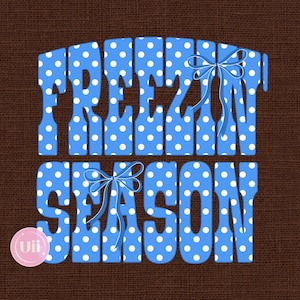 May include: A graphic design featuring the text FREEZIN SEASON in bold, light blue letters with a white polka dot pattern. The letters are decorated with two light blue ribbon bows. The background is a dark brown, textured fabric pattern.