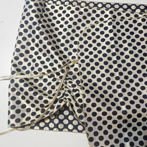 Navy and gold polka dot evening wrap laid flat showing its reversible construction and ribbon ties