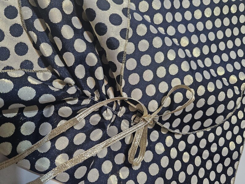Satin ribbon fastening detail on the reversible navy and gold polka dot formal shoulder wrap