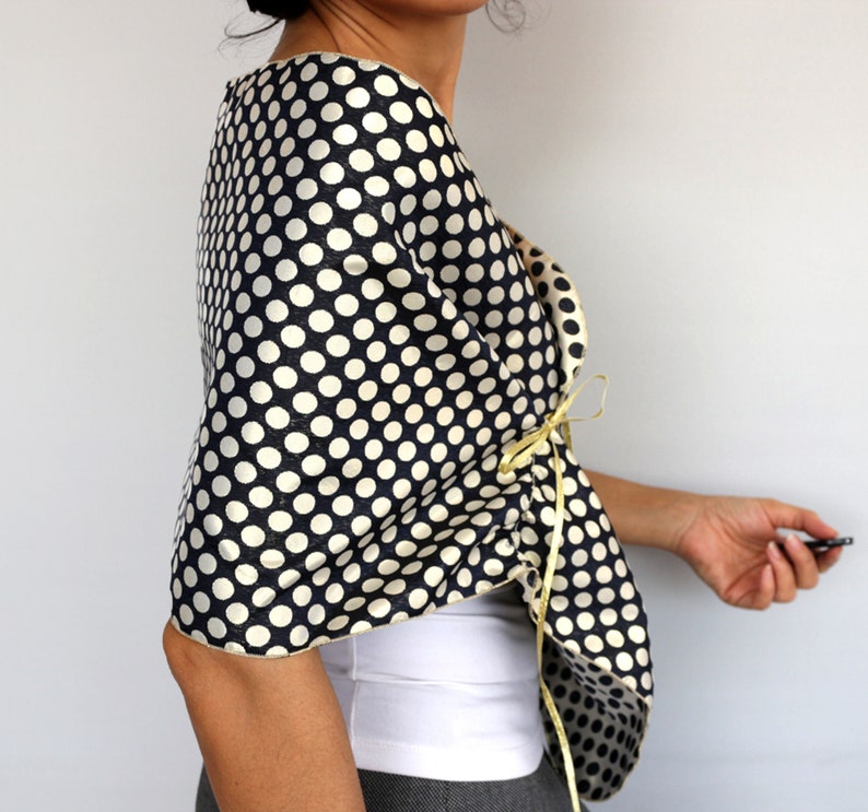 Navy polka dot evening shawl draped over the shoulders and secured with satin ribbon ties