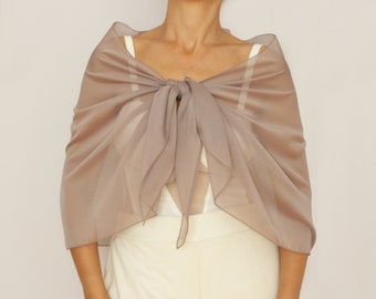 Pode incluir: Um xale de chiffon cor de areia claro amarrado no pescoço. O xale é feito de um tecido macio e fluido, perfeito para adicionar um toque de elegância a qualquer roupa.