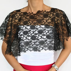 Peut inclure: Chale en dentelle noire avec un motif floral. Le châle est transparent et a un bord festonné.
