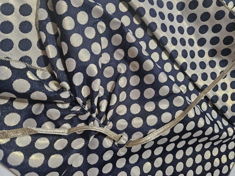 Close-up of navy polka dot taffeta and satin ribbon tie used to secure the shawl