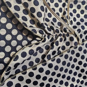 Close-up showing both sides of the reversible navy and gold polka dot taffeta fabric