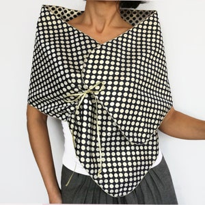 Navy and gold polka dot formal dress cover up worn as a hands-free shoulder wrap