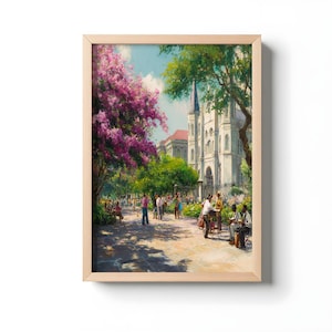 Puede incluir: Una impresión artística enmarcada de una escena de parque con una iglesia al fondo. La obra de arte presenta una vibrante exhibición de árboles de flores rosas, exuberante follaje verde y personas paseando por un sendero de piedra. El cielo es azul brillante con nubes blancas esponjosas.