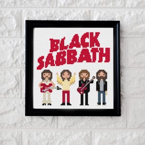 Op de afbeelding: Een ingelijste kruissteek met de band Black Sabbath. De naam van de band staat in rode blokletters boven vier gepixelde figuren die gitaren vasthouden. De lijst is zwart en de achtergrond is wit.