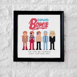 May include: Cross-stitch pattern featuring a group of five figures, including David Bowie, with the text "David Bowie" and "We can be heroes just for one day".