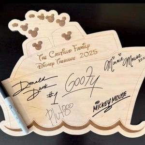May include: A wooden ship-shaped sign with the text "The Castillo Family Disney Treasure 2025" and signatures from Mickey Mouse, Minnie Mouse, Goofy, Donald Duck, and Pluto.