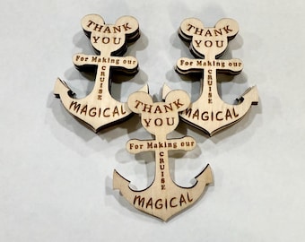 May include: Three wooden anchor-shaped ornaments with a Mickey Mouse head design at the top. Each ornament has the words "THANK YOU" and "For Making our CRUISE MAGICAL" engraved on it. The ornaments are light brown.