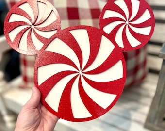 Puede incluir: Decoraciones navideñas de madera en forma de bastón de caramelo rojo y blanco. Los bastones de caramelo están hechos de madera y tienen un acabado brillante.