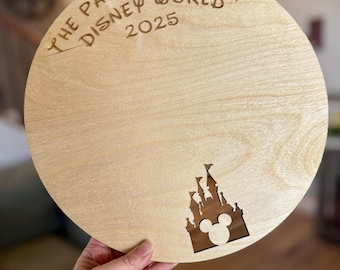 May include: A round wooden sign with the text "The Parsons Family Disney World 2025" engraved on it. The sign has a cutout of the Disney castle with Mickey Mouse ears in the bottom right corner.