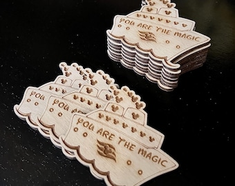 May include: A stack of wooden cruise ship ornaments with the text "You are the magic" and a Disney cruise line logo. The ornaments are decorated with Mickey Mouse heads.