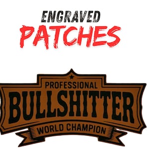 May include: A brown and black engraved patch with the text "PROFESSIONAL BULLSHITTER WORLD CHAMPION". The patch has a banner design and the words "ENGRAVED PATCHES" in red and black.