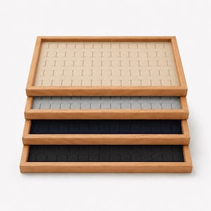 以下が含まれることがあります： 明るい茶色の木製フレームが付いた4つの長方形のジュエリーディスプレイ用トレイのスタック。各トレイには、リングやイヤリングを整理するための複数のスロットを備えた柔らかい内側の裏地があり、ベージュ、ライトグレー、ネイビーブルー、ブラックのカラーで構成されています。