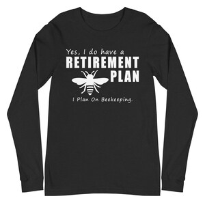 May include: Black long-sleeve shirt with white text and a bee graphic. The text reads "Yes, I do have a RETIREMENT PLAN, I Plan On Beekeeping."