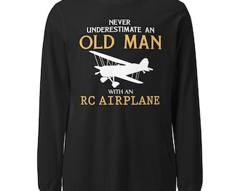May include: Black long-sleeve t-shirt with the text "Never underestimate an old man with an RC airplane" in white and yellow. A white silhouette of a small airplane is in the center of the shirt.