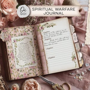 May include: Open journal with floral accents and the text "Spiritual Warfare Journal." The pages feature handwritten notes and scripture. Additional elements include a decorative card with a Bible verse and a pair of gold scissors.