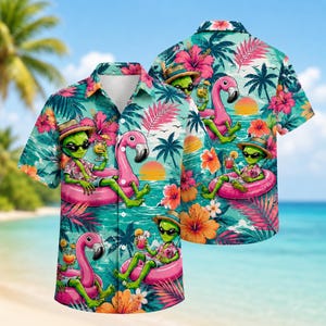 May include: A short-sleeve button-down shirt featuring a vibrant tropical print with green aliens wearing sunglasses and straw hats, lounging on pink flamingo pool floats, surrounded by hibiscus flowers, palm leaves, and a sunset over the ocean.