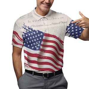 May include: A white polo shirt featuring a distressed American flag design and the text "In Congress, July 4, 1776.  He hold these truths to be self-evident, that all men are created equal..."