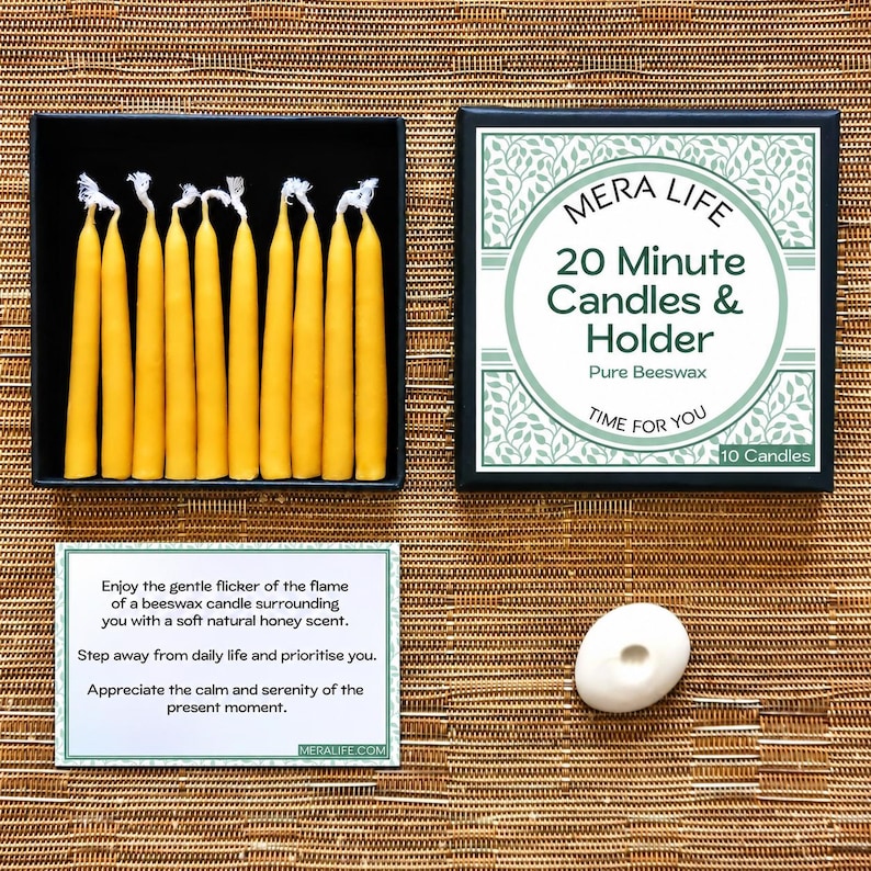 May include: A set of ten yellow beeswax candles in a black box with a lid labeled MERA LIFE 20 Minute Candles & Holder Pure Beeswax. Includes a white card with printed text and a small white oval candle holder for a single taper candle.
