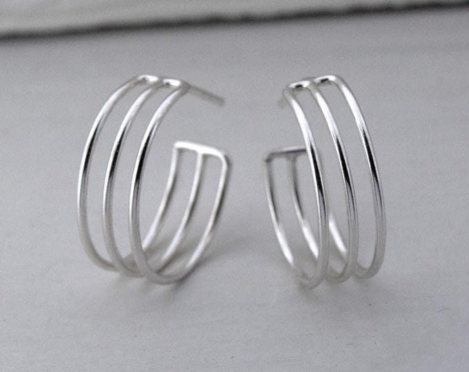 Modern silver half hoop earrings in a minimalist style, silver jewelry, women's earrings, modern earrings.