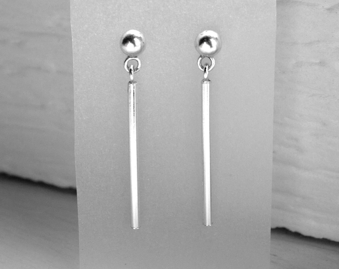 Silver dangling earrings with a tubular design, modern and minimalist style