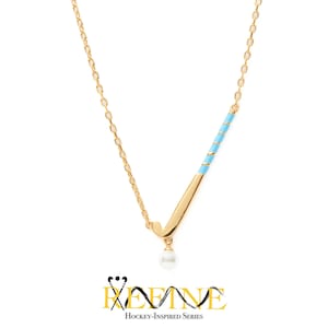 May include: Gold-toned necklace featuring a hockey stick pendant with a light blue and gold design, and a dangling pearl. The necklace is part of the "Hockey-Inspired Series" collection.