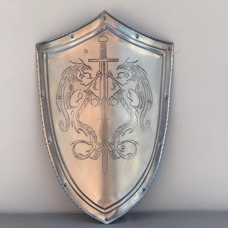 May include: A silver shield with a sword and two dragons etched into the surface.