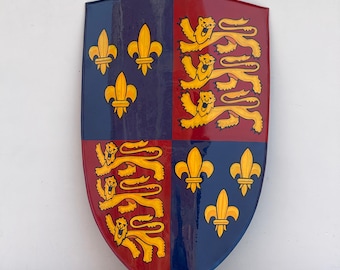 May include: A blue and red shield with a heraldic design. The shield is divided into four quarters, with three gold fleurs-de-lis in the top left and bottom right quarters, and three gold lions in the top right and bottom left quarters.