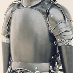 May include: Black leather and metal armor with chainmail. The armor has a chest plate, shoulder pads, and arm guards.