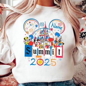 May include: White sweatshirt featuring a colourful graphic of Mickey Mouse and his friends in front of Cinderella's Castle. The graphic includes the text "Summit 2025" and a space for a name.