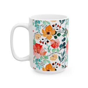 May include: White ceramic mug with a floral design featuring orange, red, and yellow flowers, green leaves, and the text "Come Through Mary", "Veni Sancte Spiritus", and "Come Holy Spirit".