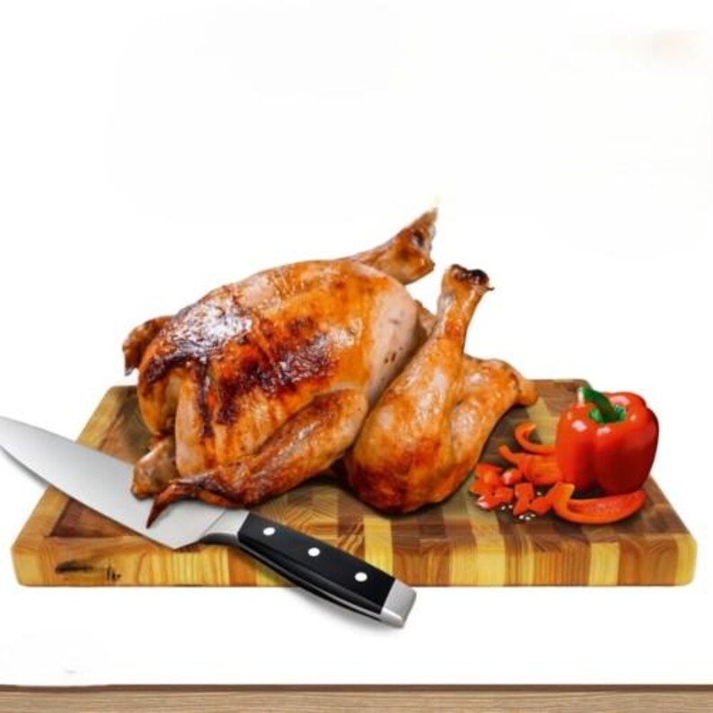 May include: A roasted whole chicken and a chicken leg on a wooden chopping board. A large knife with a black handle and a red bell pepper with sliced pieces are also on the board. The chicken has a golden-brown skin.