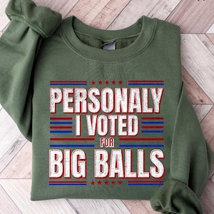 May include: Military green sweatshirt with the text "PERSONALLY I VOTED FOR BIG BALLS" in red, white, and blue. The text is centered on the front of the sweatshirt. The sweatshirt is made of a soft material.