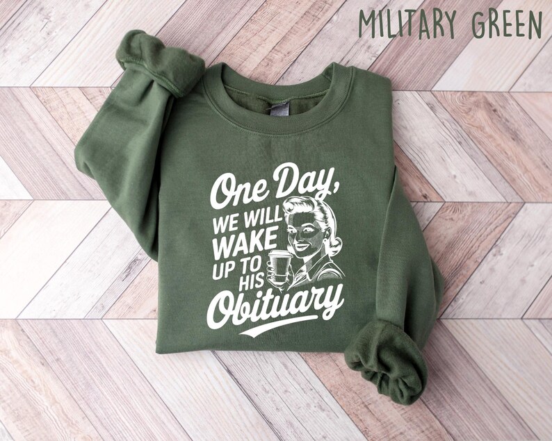 May include: A green sweatshirt with the text "One Day, We Will Wake Up To His Obituary" and a retro illustration of a woman holding a coffee cup.