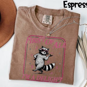 May include: A set of three ceramic mugs with a speckled, matte finish. The mugs are in shades of cream, light grey, and dark grey. Each mug has a simple, minimalist design, ideal for coffee or tea.