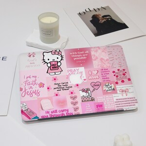 May include: A pink laptop skin featuring a collage of images and text, including a Hello Kitty illustration holding a Bible. The design incorporates floral elements, hearts, and religious phrases like "Faith in Jesus" and "God will provide."
