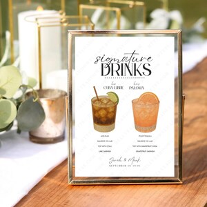Puede incluir: Un letrero enmarcado en dorado muestra "signature DRINKS" sobre ilustraciones de cócteles Cuba Libre y Paloma, con sus recetas. El letrero incluye los nombres "Sarah & Mark" y una fecha.