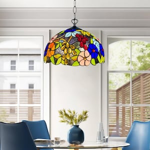 May include: A colorful stained glass pendant light with a floral design. The lamp features a variety of colors, including blue, orange, red, and green. It hangs from a chain and is suspended above a dining table. The lamp's design includes flowers and grape clusters.