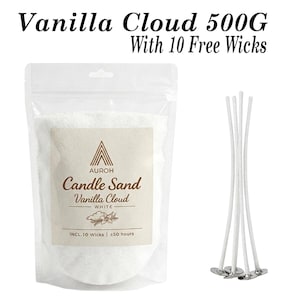 May include: A 500g bag of white granular candle sand labelled Vanilla Cloud by AUROH, featuring a beige rectangular label with text and a vanilla flower graphic. The set includes 10 white candle wicks with metal bases positioned to the right.