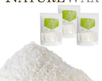 May include: A large pile of white soy wax flakes positioned in front of three white pouches labeled NatureWax Soy Wax Flakes. Each pouch features a green label with the text 2.2LBS / 1KGS, indicating the weight of the contents inside the packaging.