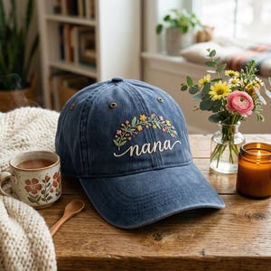 May include: A white ceramic mug with a black handle and the text "But First, Coffee" in a black, bold font. The mug is on a white surface.
