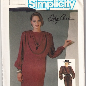 Puede incluir: Patrón de costura Simplicity nº 12 para un vestido diseñado por Oleg Cassini. El patrón presenta un vestido de manga larga con cuello de pico y una silueta ajustada. La modelo lleva un vestido burdeos con un cinturón negro.