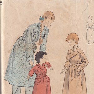 May include: Vintage Vogue sewing pattern number 2658 for a robe, size 10. The pattern shows three people wearing robes: a woman in a blue and white robe, a girl in a red robe, and a boy in a brown robe.