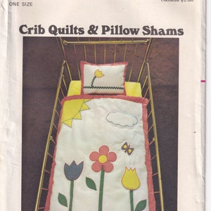 Könnte beinhalten: Ein Vintage-Nähmuster für Kinderbettdecken und Kissenbezüge. Das Muster zeigt ein Kinderbett mit einer weißen Bettdecke mit einer gelben Sonne, einer weißen Wolke, einer roten Blume, einer blauen Tulpe, einer gelben Tulpe und einem Schmetterling. Der Kissenbezug ist weiß mit einer gelben Blume und einem grünen Stiel.
