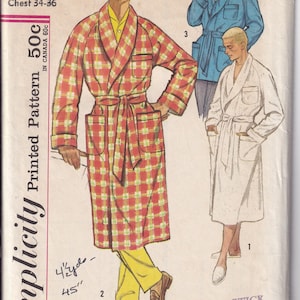 May include: A Simplicity sewing pattern envelope numbered 2312 for a robe with a shawl collar and patch pockets. The illustration displays three variations: a red and yellow plaid robe, a solid blue robe, and a solid white robe, all with belts.